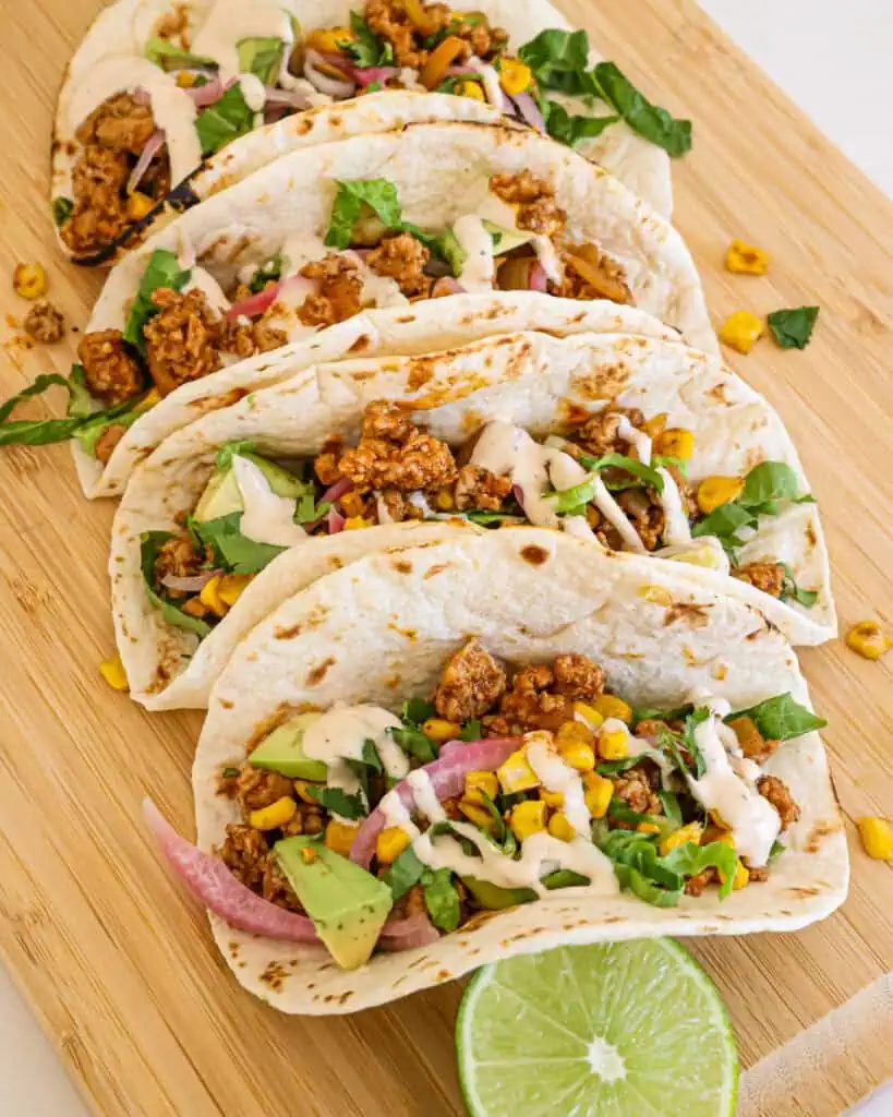 Ground pork tacos with blackened corn, lettuce, cilantro, avocado, pickled red onions, and chipotle ranch. 