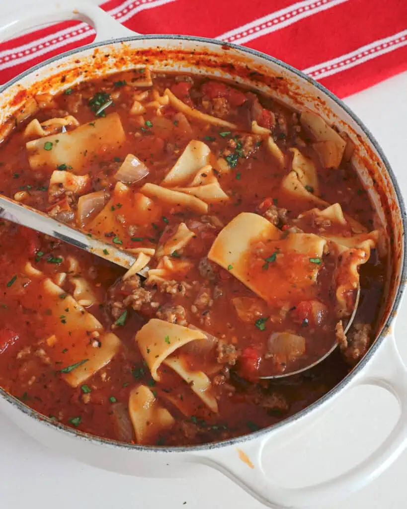 A Dutch oven full of lasagna soup with Italian Sausage, crushed tomatoes, lasagna noodles and a perfect blend of spice. 