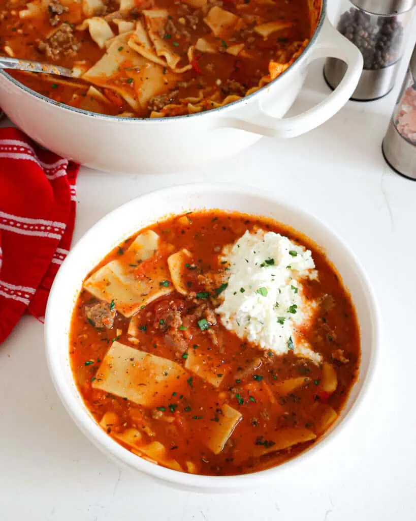 An overhead view of lasagna soup with a ricotta cheese mixture on the top. 